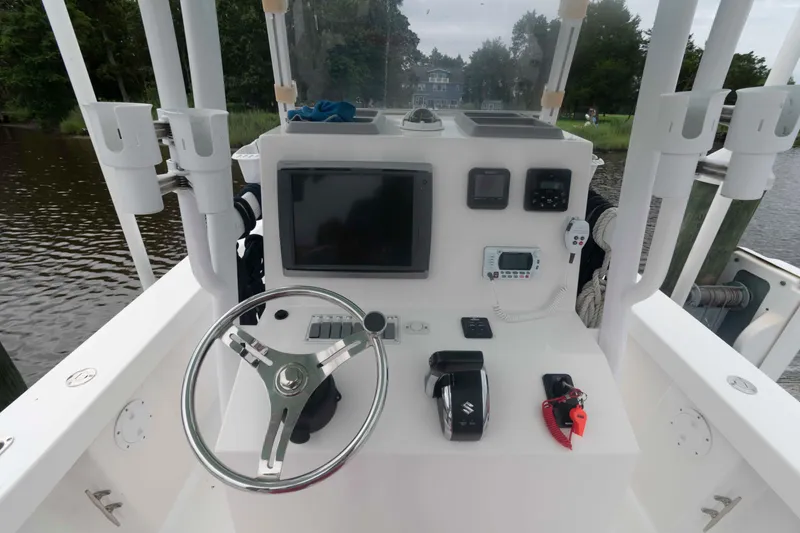 Slide: The Image of 2023 Rambo 27 Center Console boat dashboard with steering wheel and navigation controls. - 8