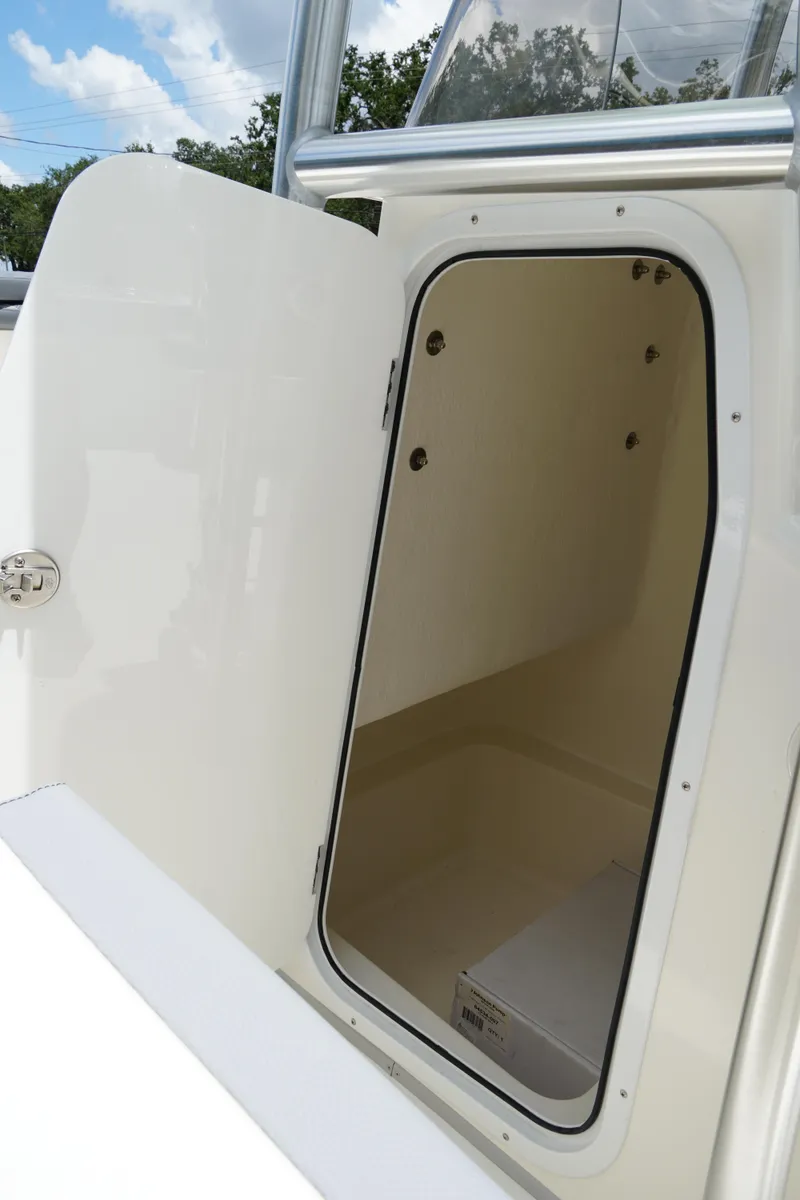 Slide: The Image of 2026 May-Craft 245 Offshore CC storage compartment with open door, showcasing interior space. - 29