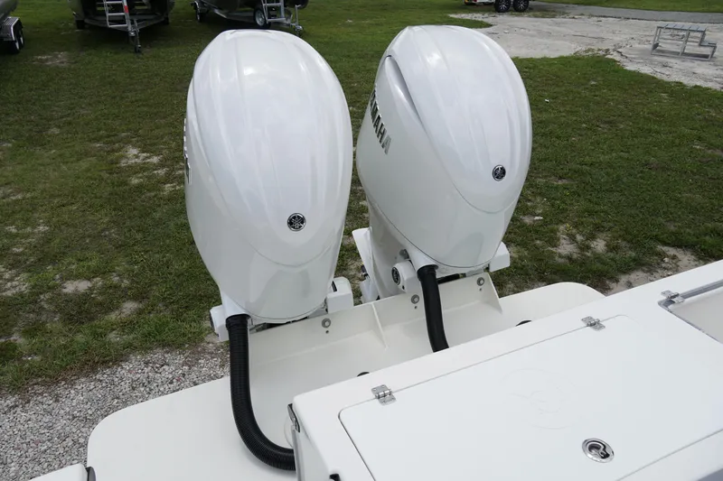 Slide: The Image of 2026 May-Craft 245 Offshore CC with dual Yamaha outboard engines on grassy area. - 6