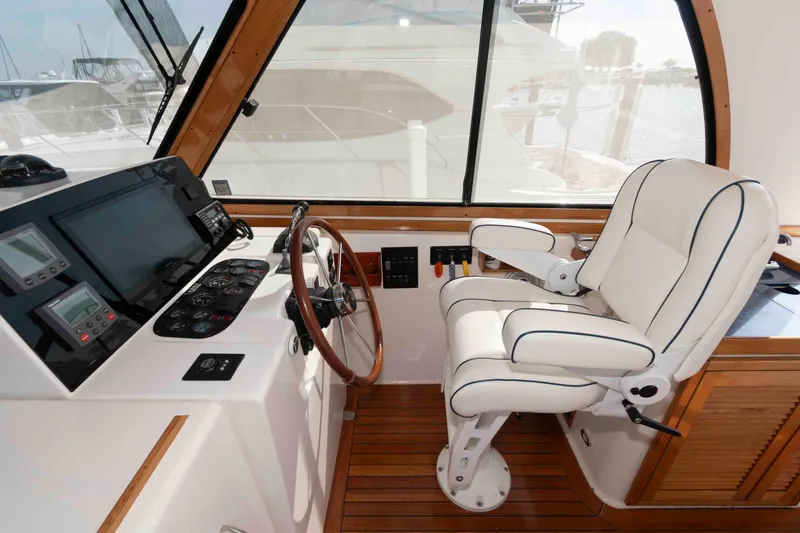 Slide: The Image of 2003 Sabre 42 Express helm with white captain's chair and wooden steering wheel. - 11