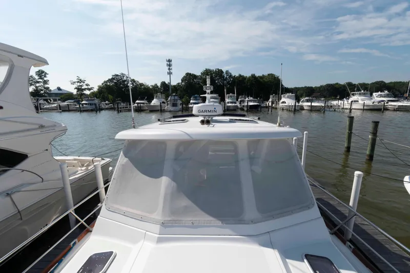 Slide: The Image of 2003 Sabre 42 Express yacht docked at a marina with other boats. - 18