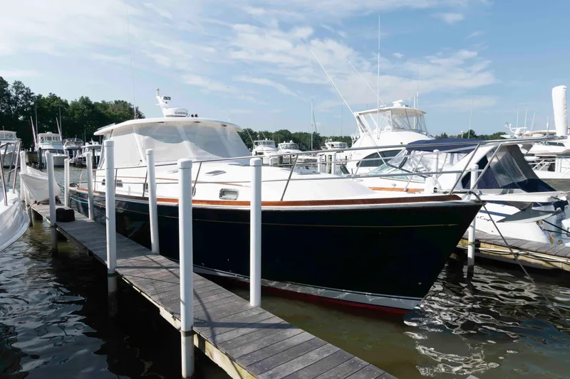 Slide: The Image of 2003 Sabre 42 Express yacht docked at marina under clear sky. - 2