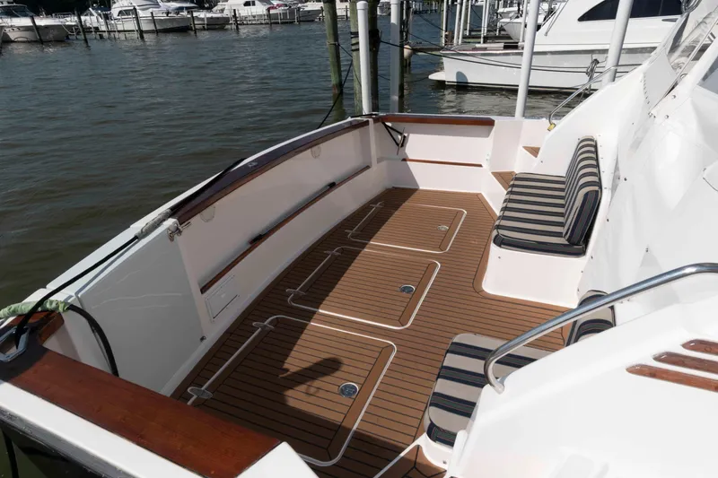 Slide: The Image of 2003 Sabre 42 Express boat deck with striped seating, docked at marina. - 3