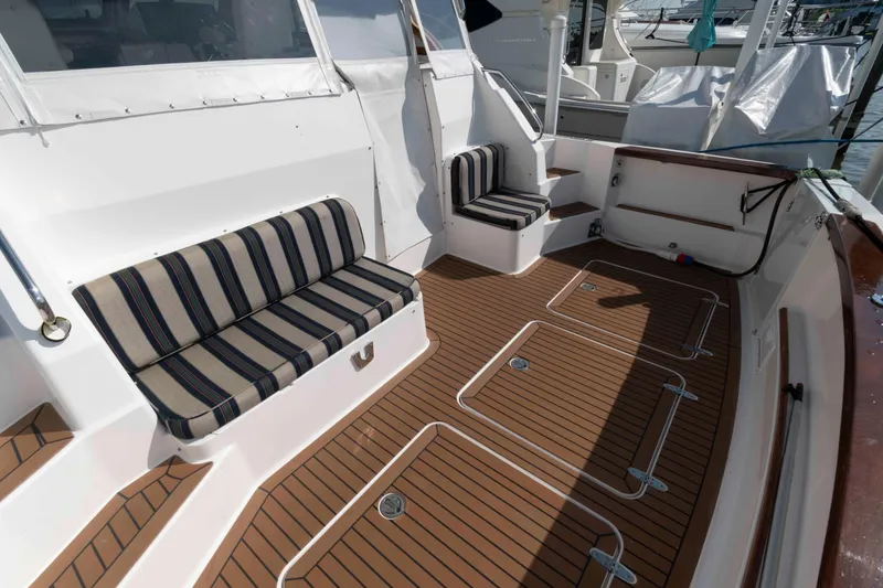 Slide: The Image of 2003 Sabre 42 Express boat deck with striped seating and teak flooring. - 4