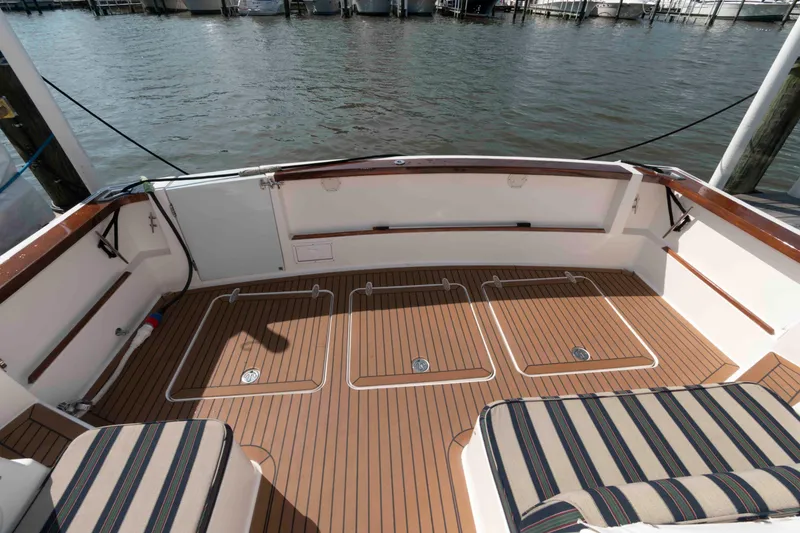 Slide: The Image of 2003 Sabre 42 Express boat deck with striped seating and wooden flooring. - 5