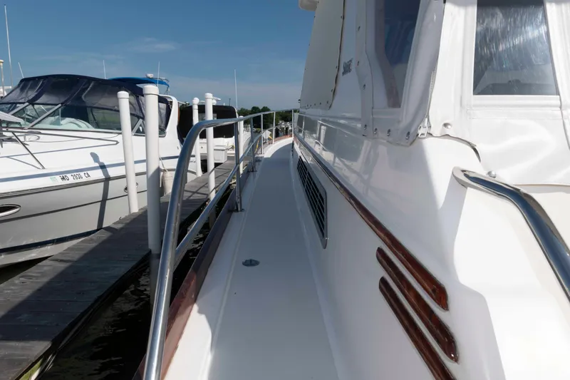 Slide: The Image of 2003 Sabre 42 Express yacht docked at marina, side view with railing and clear sky. - 6
