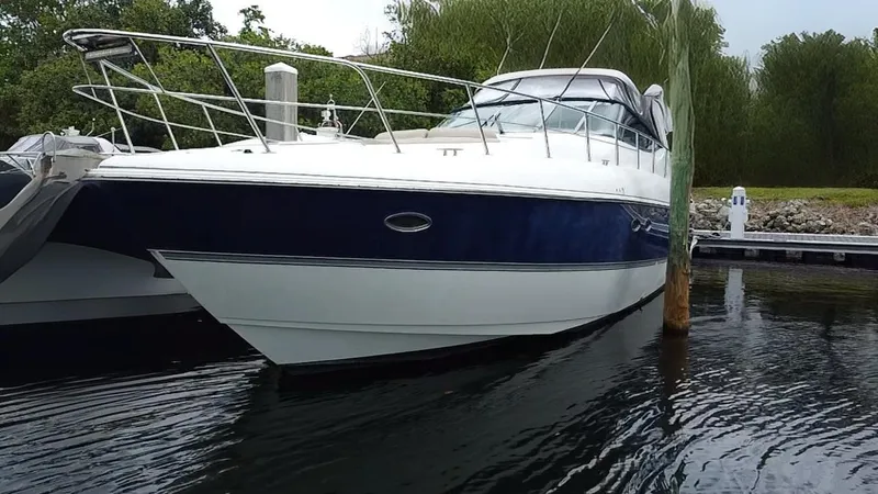 Slide: The Image of 2005 Cruisers Yachts 500 Express docked in a serene marina setting. - 2