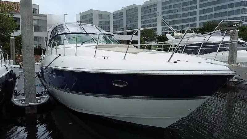 Slide: The Image of 2005 Cruisers Yachts 500 Express docked, showcasing sleek design and modern architecture in the background. - 3