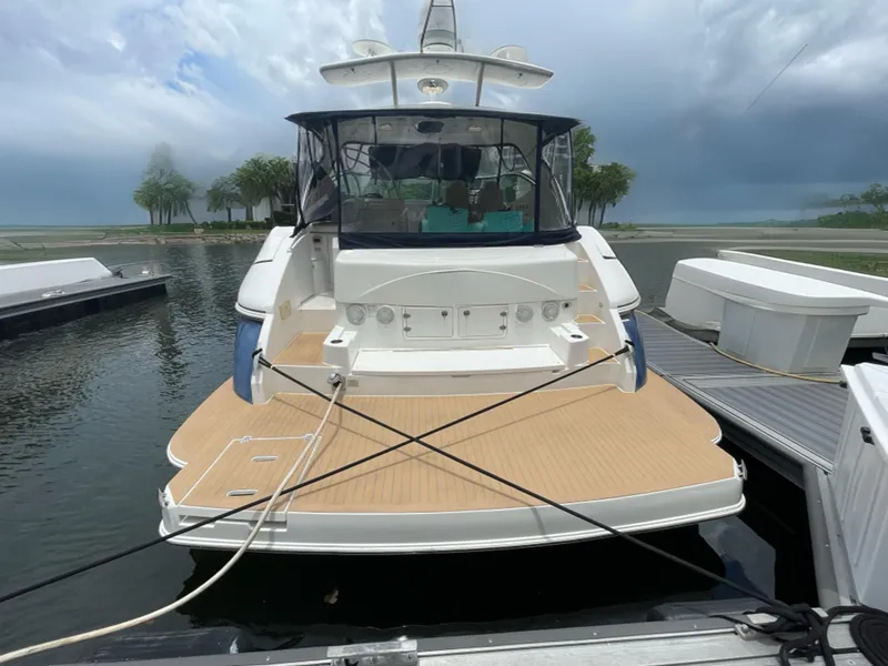 Slide: The Image of 2005 Cruisers Yachts 500 Express docked, showcasing spacious deck and sleek design. - 15