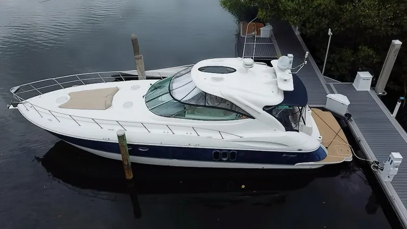 Slide: The Image of 2005 Cruisers Yachts 500 Express docked, showcasing sleek design and spacious deck. - 5