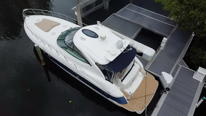 Slide: The Image of 2005 Cruisers Yachts 500 Express docked, aerial view showcasing sleek design and spacious deck. - 9