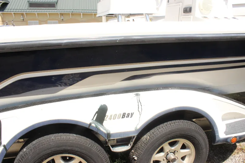 Slide: The Image of 2011 Ranger 2400 Bay boat on trailer, side view with visible tire and hull design. - 2