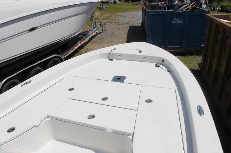 Slide: The Image of 2011 Ranger 2400 Bay Ranger boat deck, white finish, parked near trailer and storage area. - 23