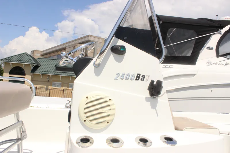Slide: The Image of 2011 Ranger 2400 Bay boat console with steering wheel and speaker, docked outdoors. - 3