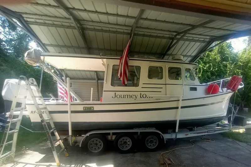 Slide: The Image of 2005 Rosborough RF-246 Sedan Cruiser on trailer under shelter with American flag. - 13