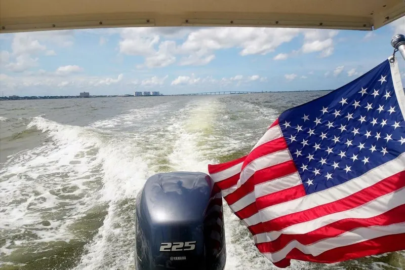 Slide: The Image of 2005 Rosborough RF-246 Sedan Cruiser with American flag and Yamaha 225 engine on open water. - 26