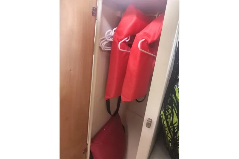 Slide: The Image of Storage closet with red life jackets on hangers in a 2005 Rosborough RF-246 Sedan Cruiser. - 56