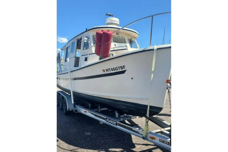 Slide: The Image of 2005 Rosborough RF-246 Sedan Cruiser on trailer, featuring a white hull and red buoy. - 6