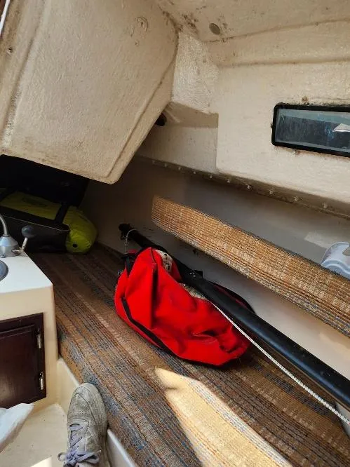 Slide: The Image of Interior of a 1982 Starwind 19 sailboat with red bag and striped flooring. - 13