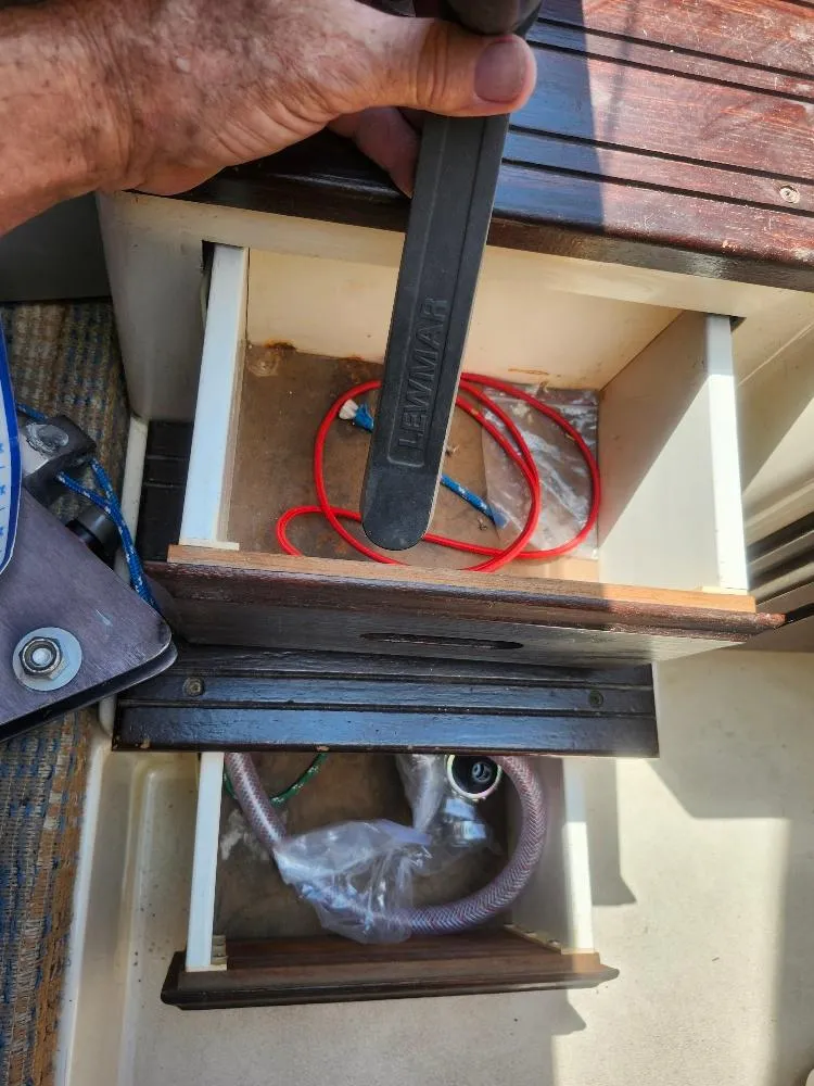 Slide: The Image of Hand holding a Lewmar winch handle above open compartments on a 1982 Starwind 19 sailboat. - 14