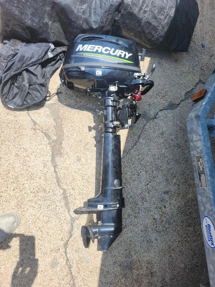 Slide: The Image of Mercury outboard motor on concrete, next to a Starwind 19 sailboat, 1982 model. - 22