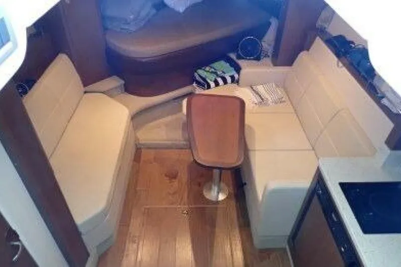 Slide: The Image of Interior of 2016 Sea Ray 350 Sundancer with beige seating and compact kitchen area. - 109