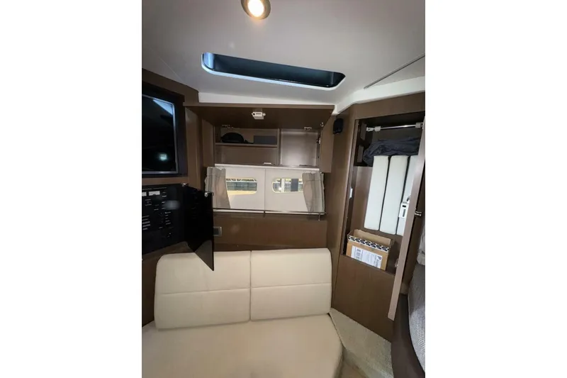 Slide: The Image of 2016 Sea Ray 350 Sundancer interior with wooden paneling and cushioned seating. - 121