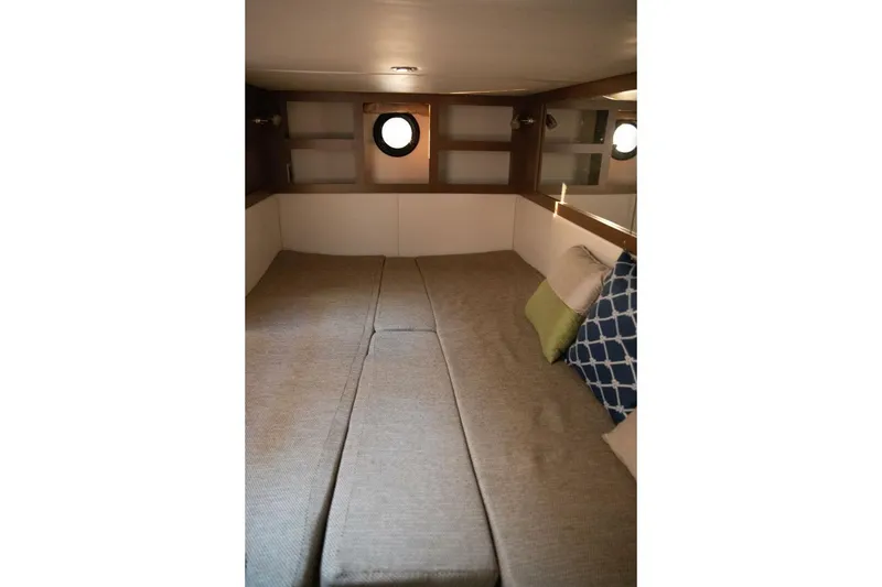 Slide: The Image of 2016 Sea Ray 350 Sundancer cabin interior with cozy bedding and decorative pillows. - 126