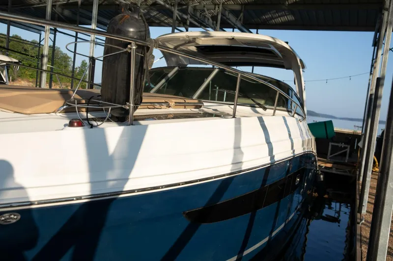 Slide: The Image of 2016 Sea Ray 350 Sundancer boat deck with sunbed and calm water view. - 18