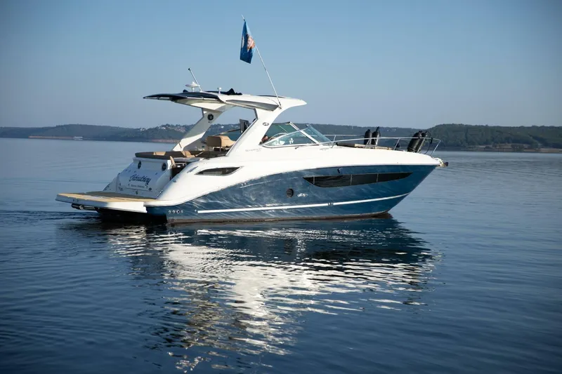 Slide: The Image of 2016 Sea Ray 350 Sundancer boat with beige seating and table, cruising on water. - 34