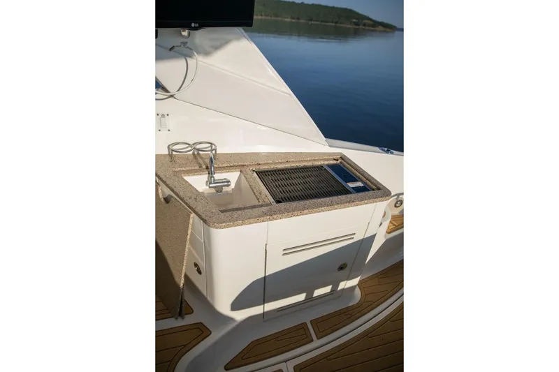 Slide: The Image of Outdoor kitchenette on 2016 Sea Ray 350 Sundancer with grill and sink. - 60
