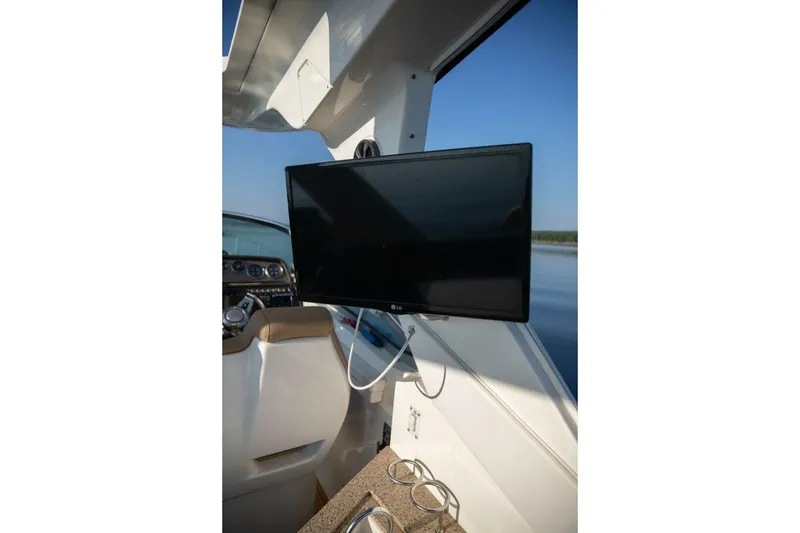 Slide: The Image of Cockpit of 2016 Sea Ray 350 Sundancer with steering wheel and navigation controls. - 64