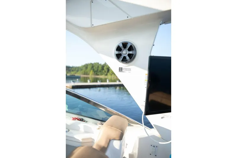 Slide: The Image of 2016 Sea Ray 350 Sundancer yacht interior with seating and open deck on calm water. - 76