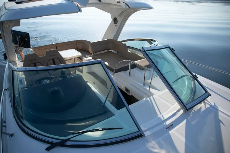 Slide: The Image of 2016 Sea Ray 350 Sundancer boat with open deck and seating area on calm water. - 77