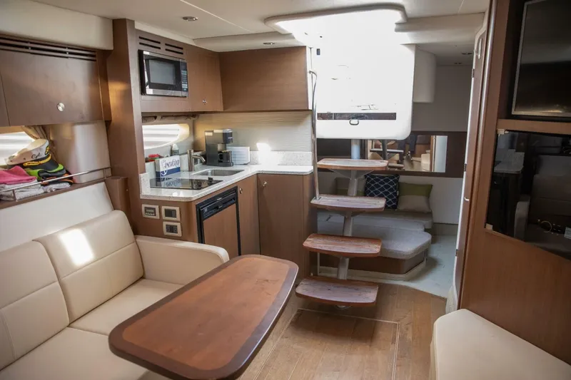 Slide: The Image of 2016 Sea Ray 350 Sundancer interior with modern kitchen, seating, and entertainment area. - 90