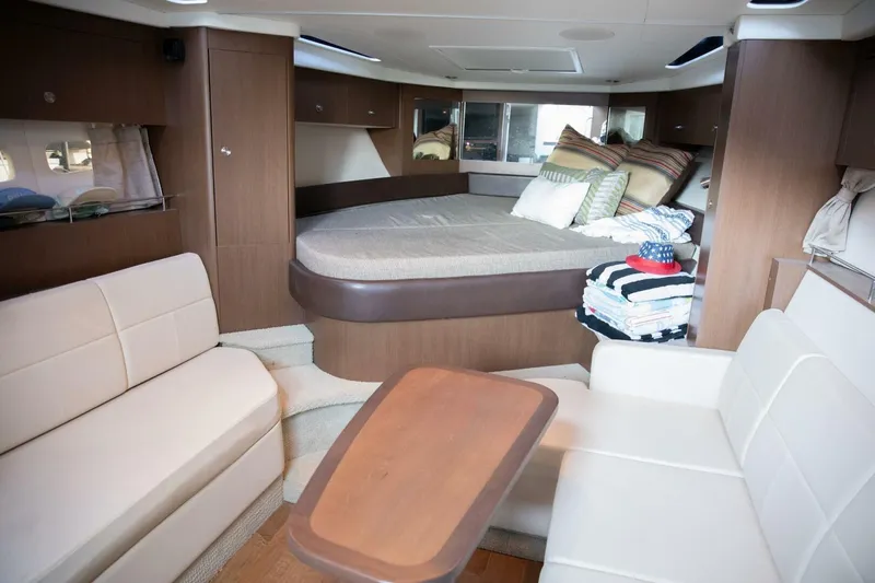 Slide: The Image of 2016 Sea Ray 350 Sundancer cabin with cozy bed and pillows. - 92