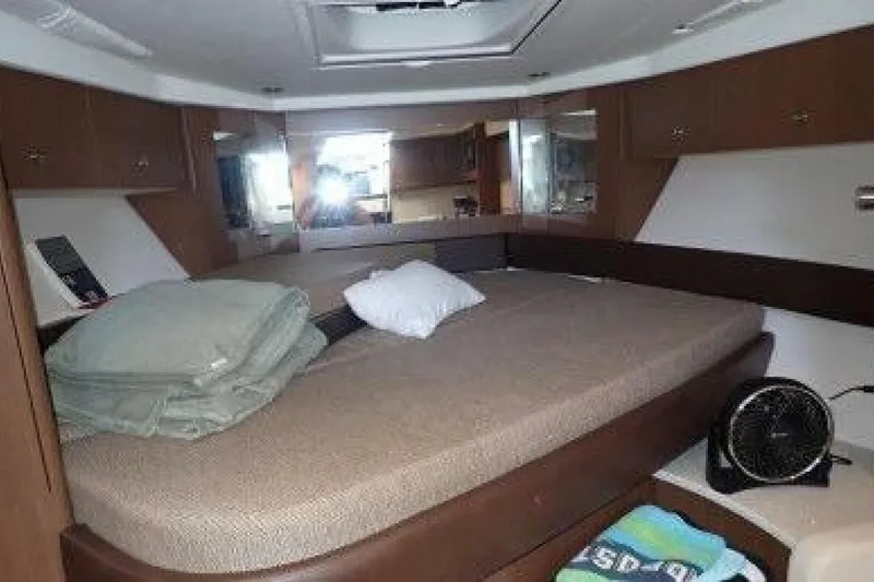 Slide: The Image of Interior of 2016 Sea Ray 350 Sundancer with cozy bed and seating area. - 94
