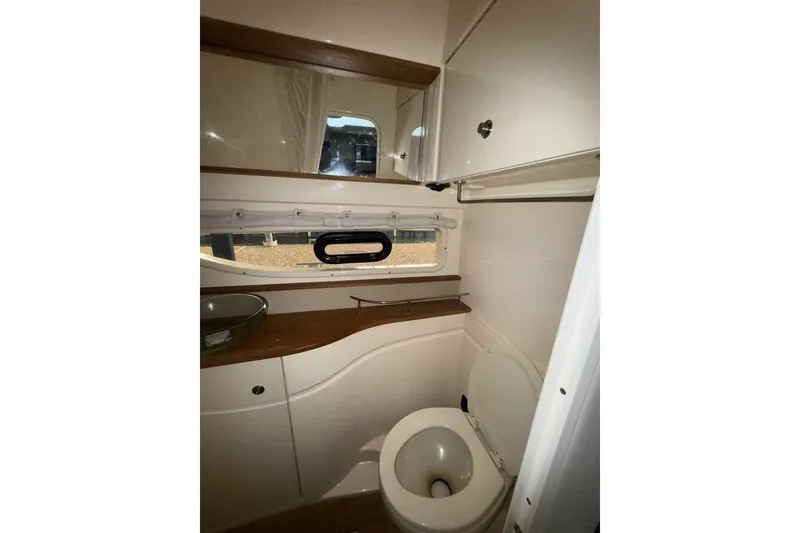 Slide: The Image of 2016 Sea Ray 350 Sundancer bathroom with glass sink and wooden countertop. - 99