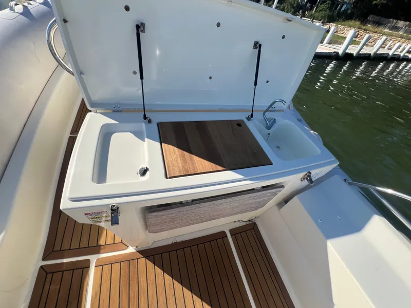 Slide: The Image of 2015 Zodiac N-ZO 760 boat with open storage compartment and sink on deck. - 13