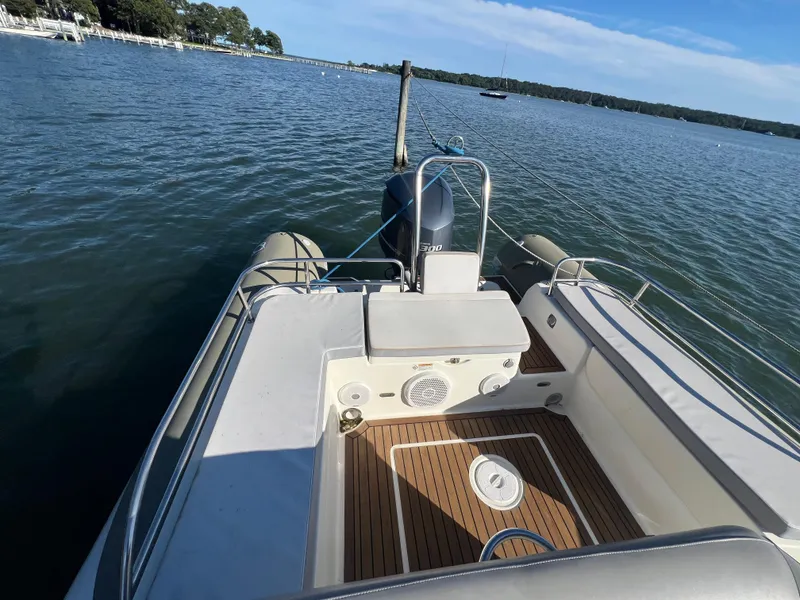 Slide: The Image of 2015 Zodiac N-ZO 760 boat on calm water, featuring spacious deck and seating area. - 14