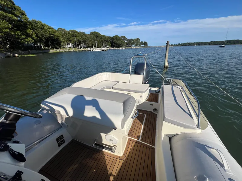 Slide: The Image of 2015 Zodiac N-ZO 760 boat on calm water, featuring spacious seating and scenic shoreline view. - 18