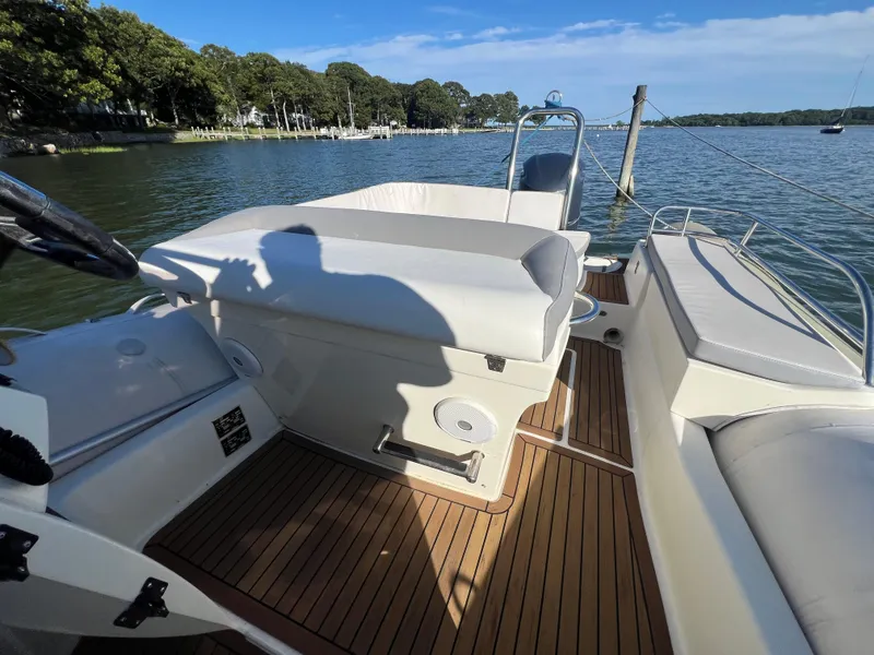 Slide: The Image of 2015 Zodiac N-ZO 760 boat interior with cushioned seating and wooden deck. - 2