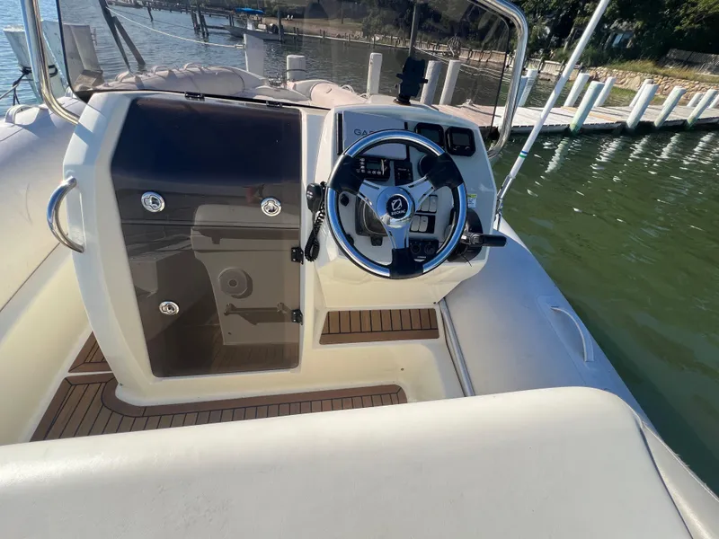 Slide: The Image of 2015 Zodiac N-ZO 760 boat cockpit with steering wheel, docked by the water. - 3