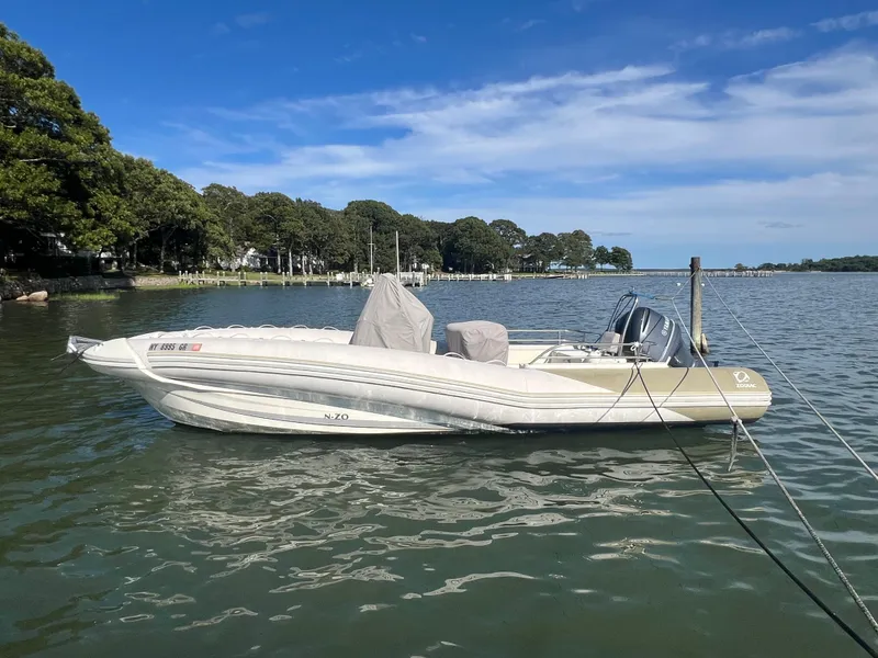 Slide: The Image of 2015 Zodiac N-ZO 760 boat moored on a calm lake with trees in the background. - 7