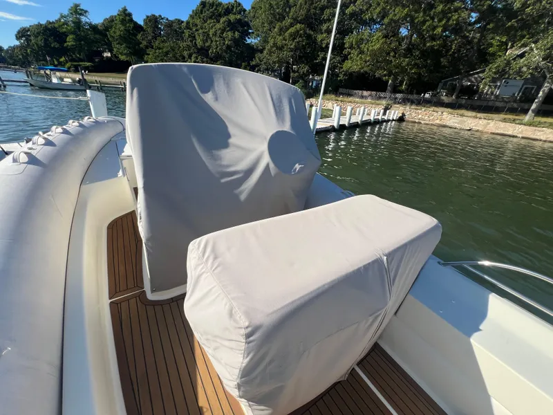 Slide: The Image of 2015 Zodiac N-ZO 760 boat with covered seats, docked by a scenic waterfront. - 9