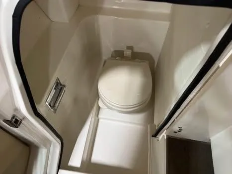 Slide: The Image of 2015 Sea Ray 250 SLX boat interior with compact marine toilet. - 11