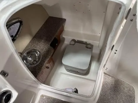 Slide: The Image of 2011 Chaparral 264 Sunesta boat interior with sink and portable toilet. - 11