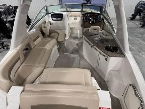 Slide: The Image of 2011 Chaparral 264 Sunesta boat interior with beige seating and helm. - 6