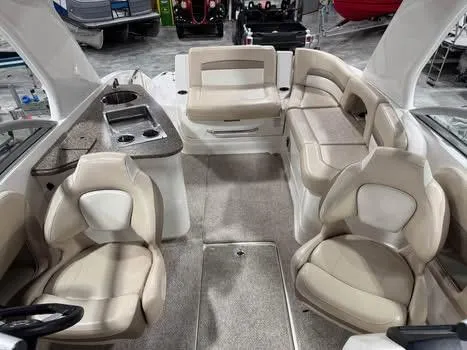 Slide: The Image of 2011 Chaparral 264 Sunesta boat interior with beige seating and kitchenette. - 8