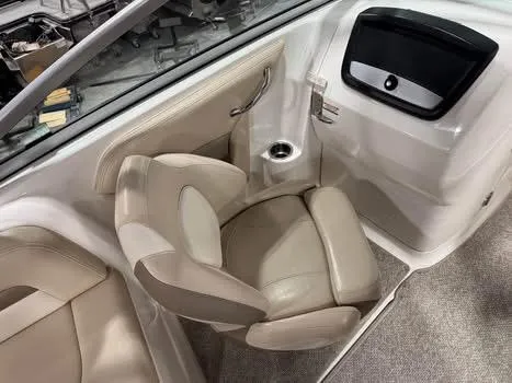 Slide: The Image of 2011 Chaparral 264 Sunesta boat interior with beige seating and cup holder. - 9